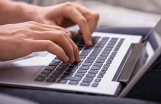 Close up of hands typing on a keyboard
