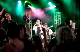 A lively image of the lead singer on stage the the 2024 presidents ball