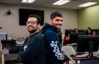 Happy international students standing back to back smiling at the camera