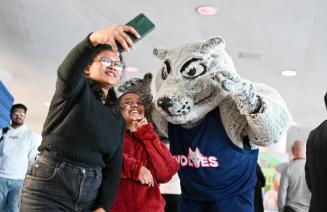Students taking a selfie with Wolves mascot, Farley.