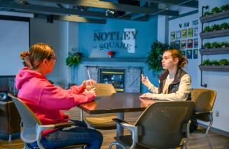 Two students socialising in the Notley Square lounge at Fairview Campus