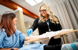 Health care aide student tending to a patient in the simulation lab