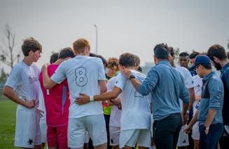 men's wolves soccer team standing in a huddle on the field during a game