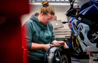 Motorcycle apprenticeship student working on a motorcycle in the workshop