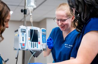 Nursing student administering an IV in the simulation lab