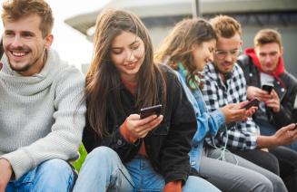 Students socialising while scrolling on their smart phones