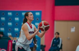 Woman wolves basketball player about to take the point shot