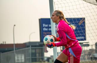 Wolves women's soccer goalie holding the ball after a save