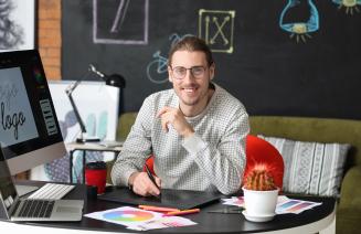 Happy graphic designer at his computer