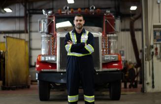 Skilled tradesperson posing in front of a semi-truck