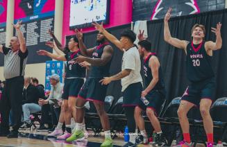 Men's basketball team reacting enthusiastically to an exciting play on the court