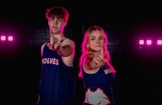 Two wolves cross country athletes holding their index fingers up