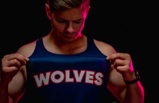 wolves cross country athlete showing the logo on the breast of his running vest