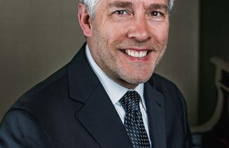 Headshot of a happy Roger Admiral sitting at his piano