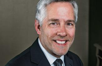 Headshot of a happy Roger Admiral sitting at his piano