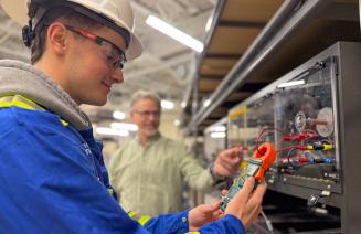 Electrical student using a device to measure electrical charge in the Ovintive Tool Hub