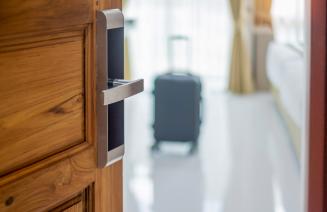 Hotel room door with a suitcase in the room