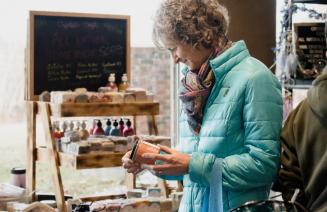 A customer perusing product at a vendor's stall at a craft market