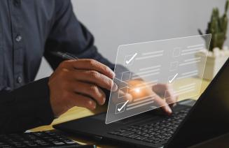 hands at a laptop selecting a checkbox on an online assessment questionnaire