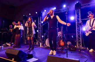 The lively band singinig enthusiastically on stage at the Presidents Ball
