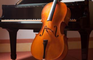Cello leaning against a grand piano