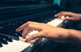 close up of a womans hands playing the piano