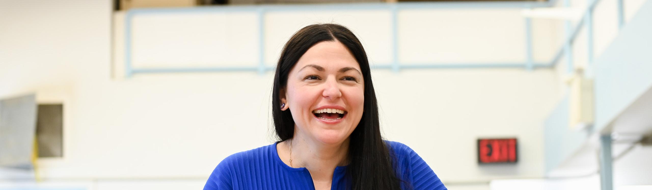 Fine Arts instructor, Laura Marotta shares a laugh while displaying an art installation