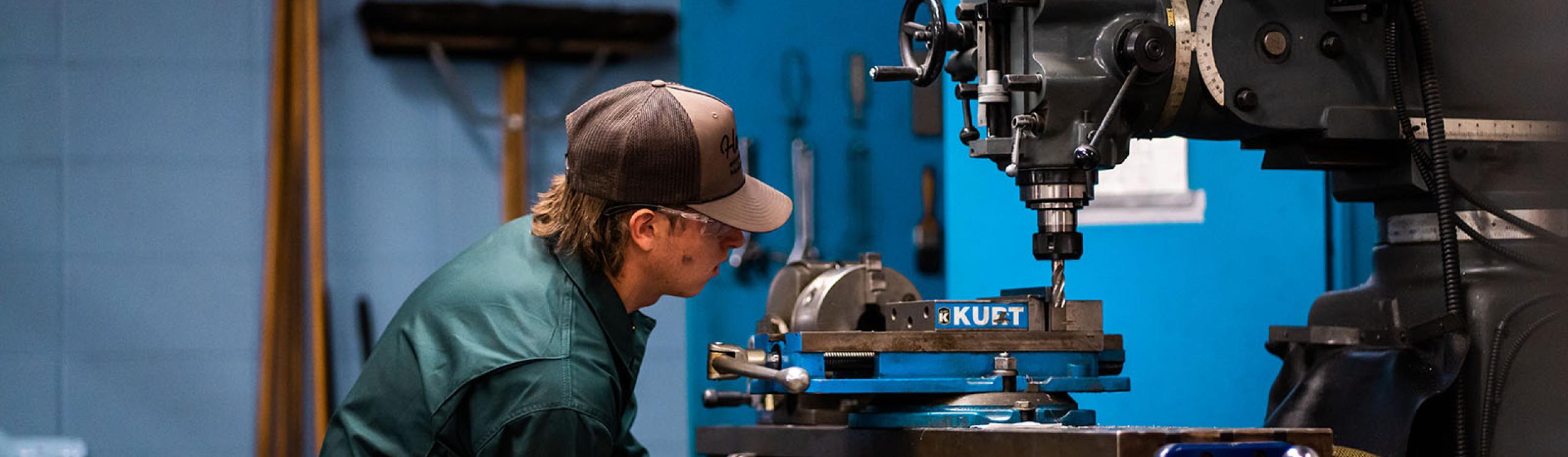 A tradesperson diligently operating a large piece of industrial equipment in a well equipped workshop.