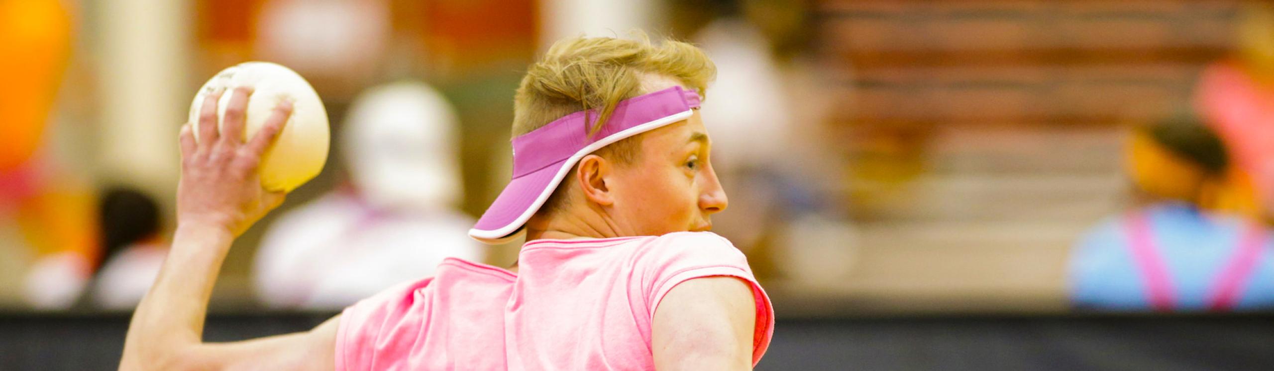 Student in brightly coloured clothing about to throw a dodgeball