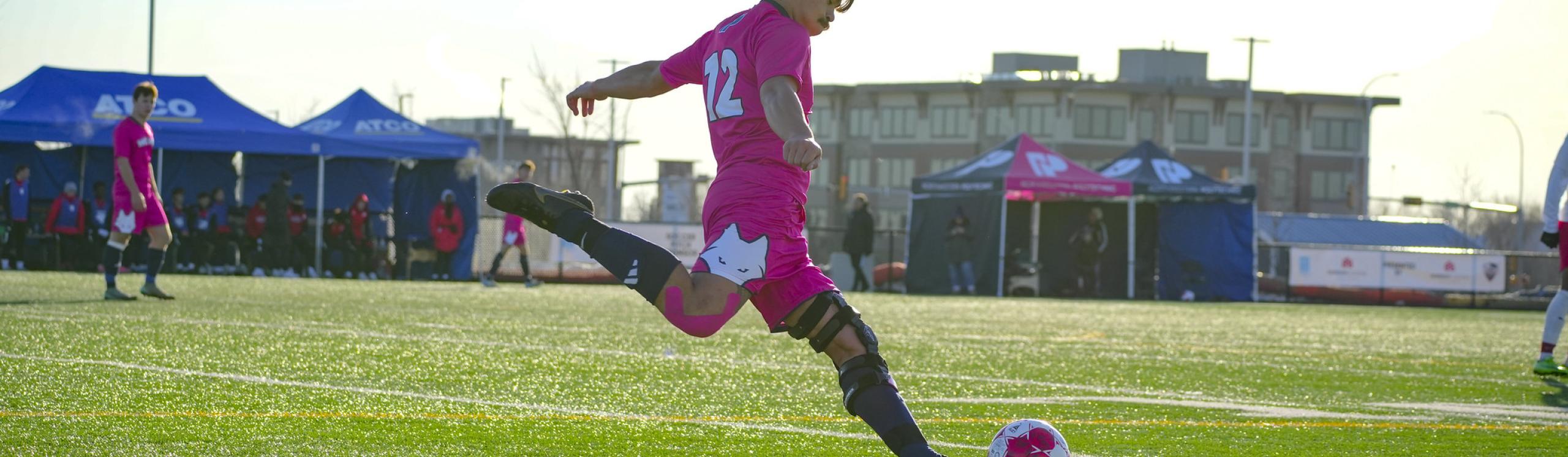 Men's soccer player taking a free kick for the Wolves