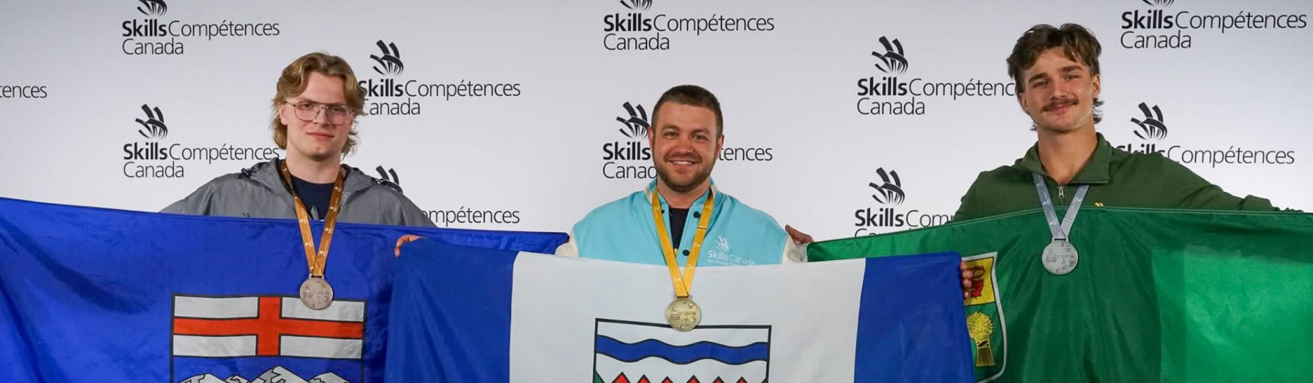 Luke Emeny holding up the Alberta flag at Skills Canada competition