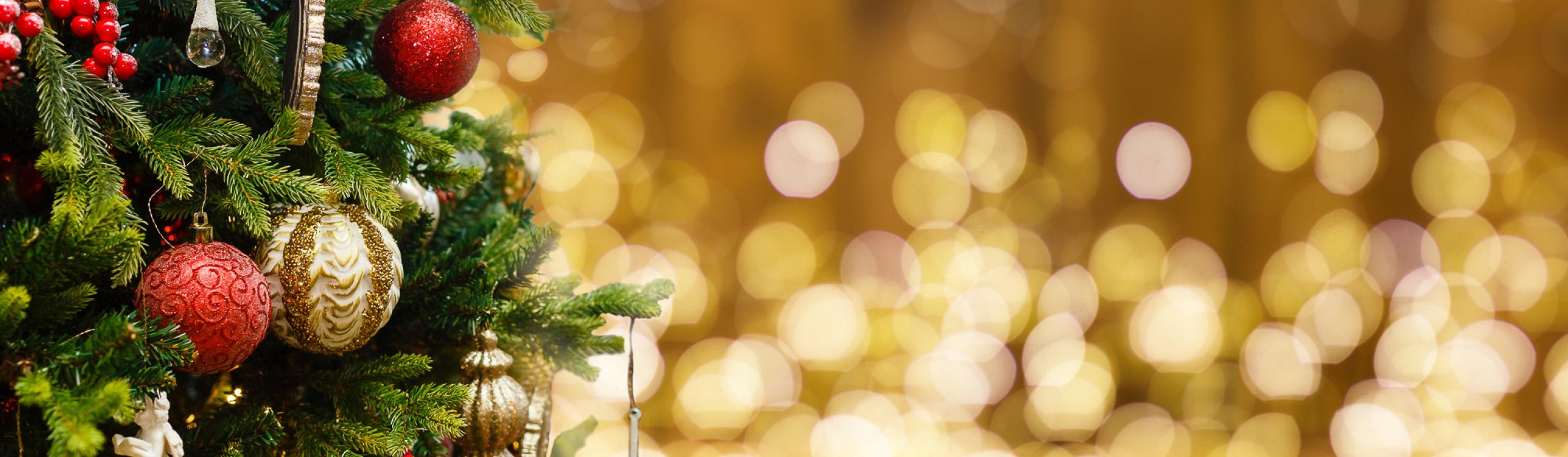 Fir Tree decorated with Christmas balls on rustic wood and sparkles light background