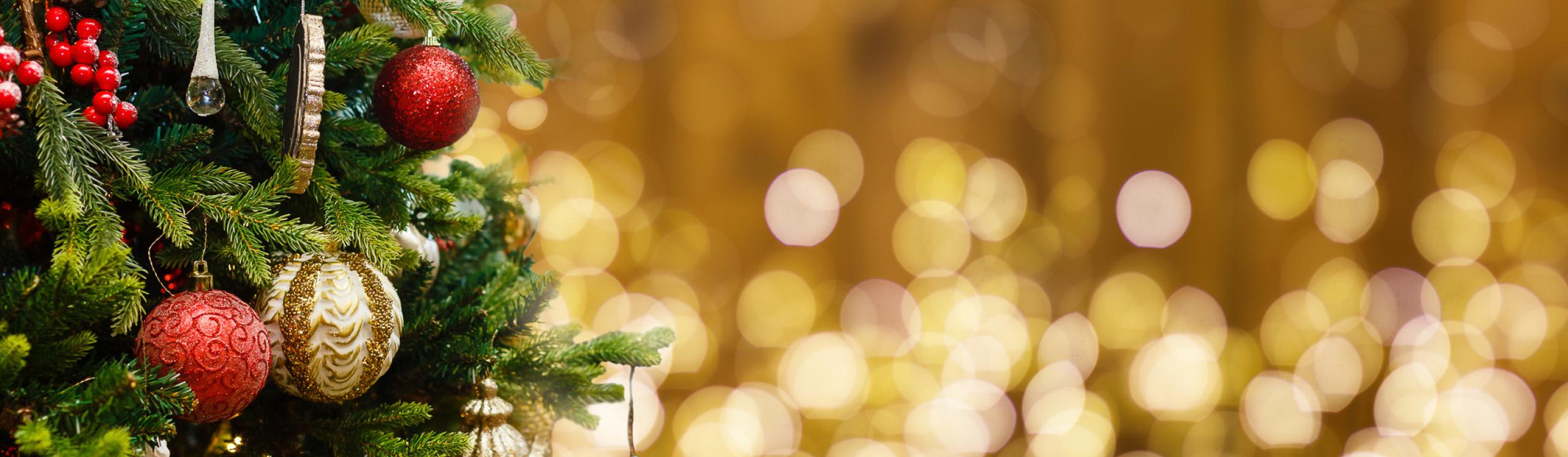 Fir Tree decorated with Christmas balls on rustic wood and sparkles light background