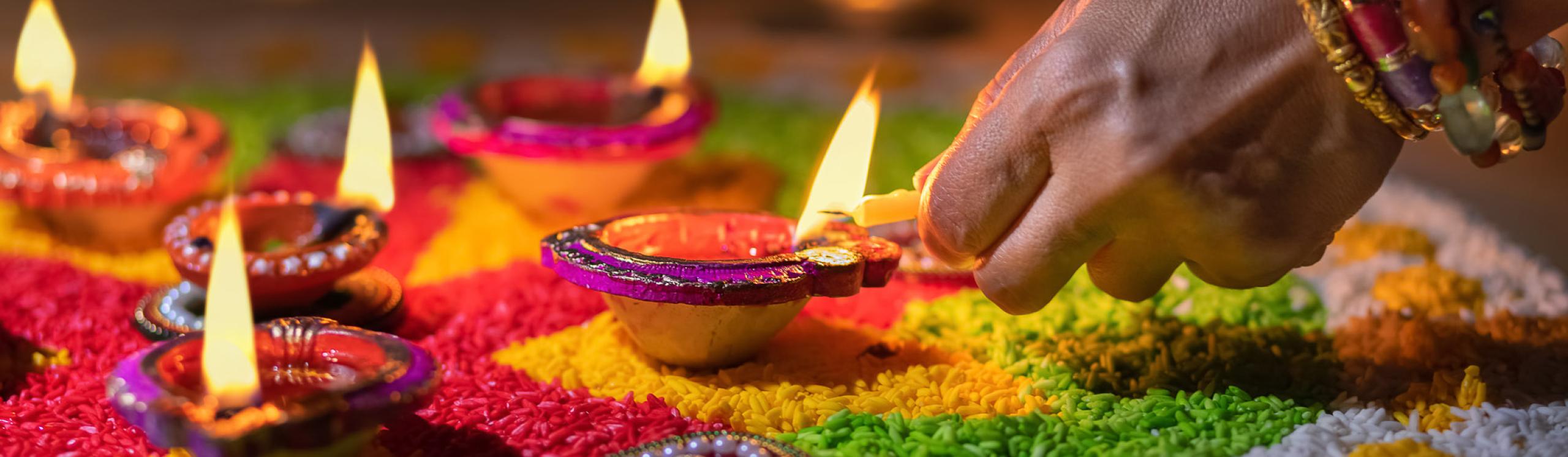 Traditional diya lamps being lit during diwali celebration