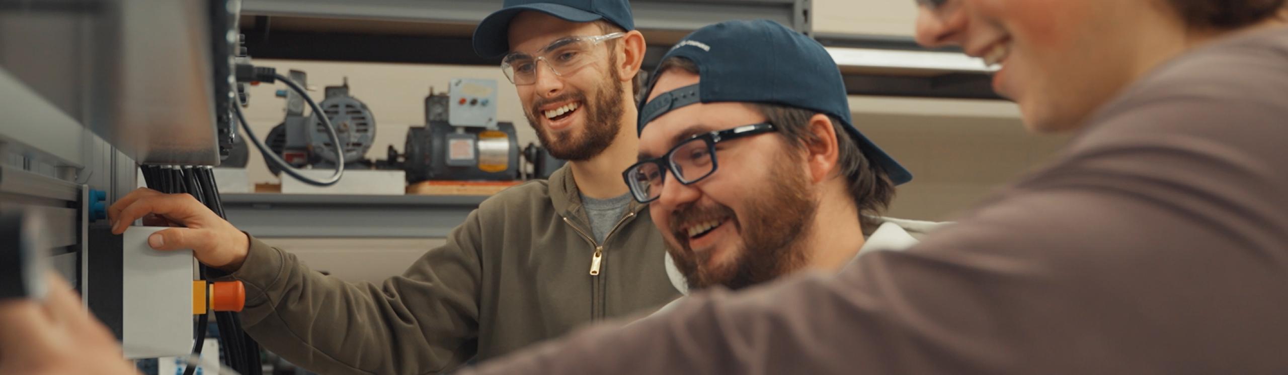 Group of happy electrical students collaborating on a project in the CDN Electrical Education Centre lab