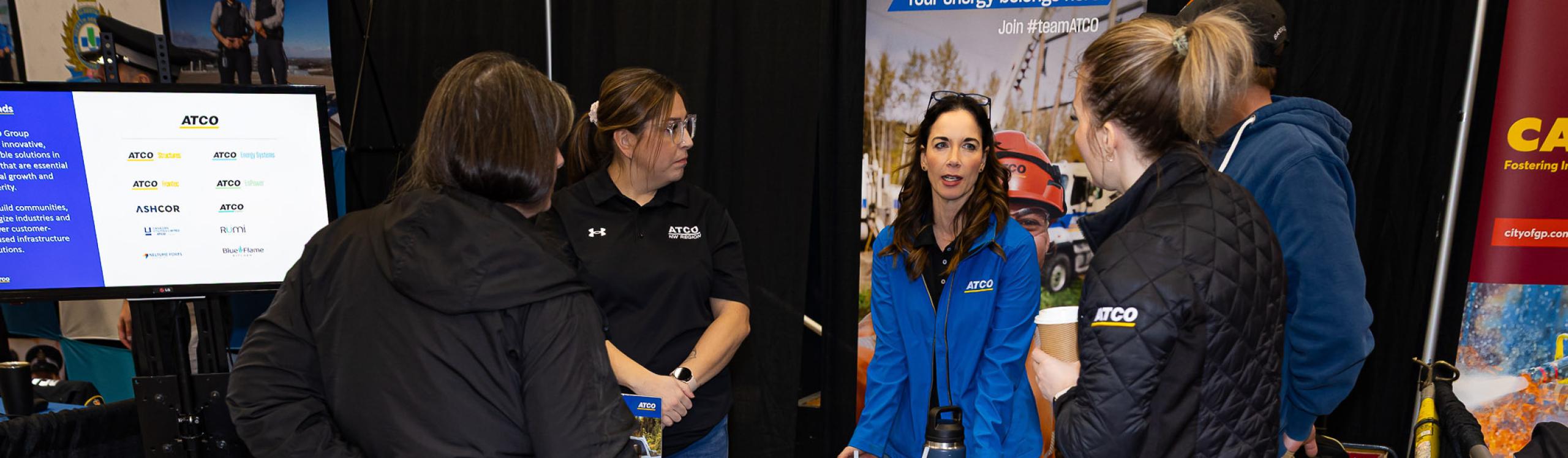 An exhibitor at the Career Fair chatting with visitors to their booth