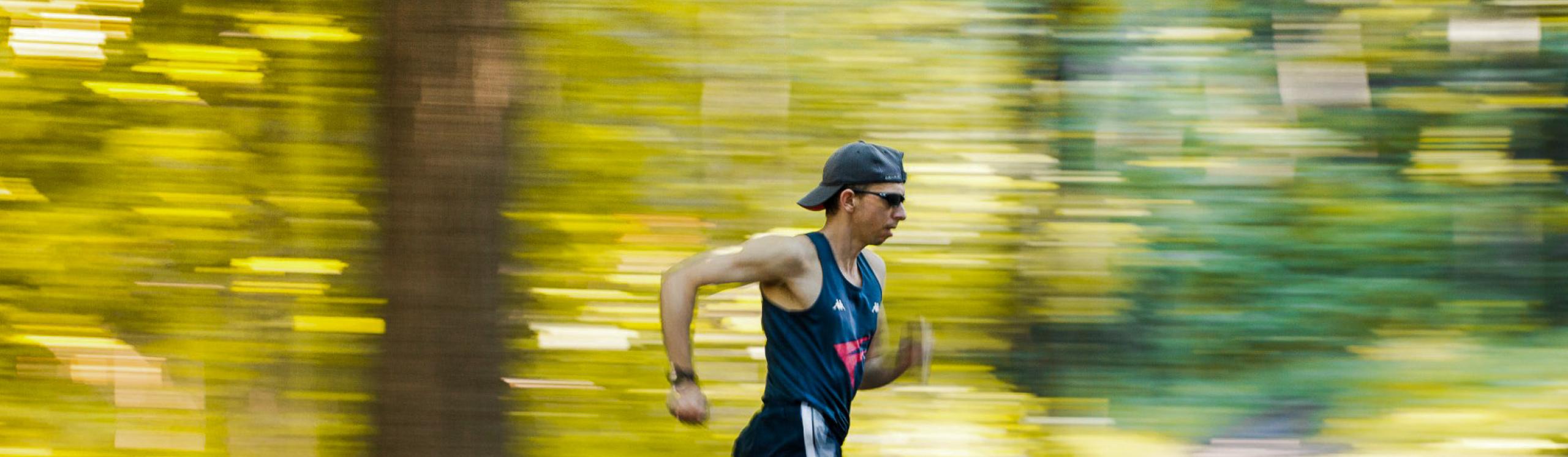 NWP Instructor, Fabio Minozzo in full stride running through a forest in the fall