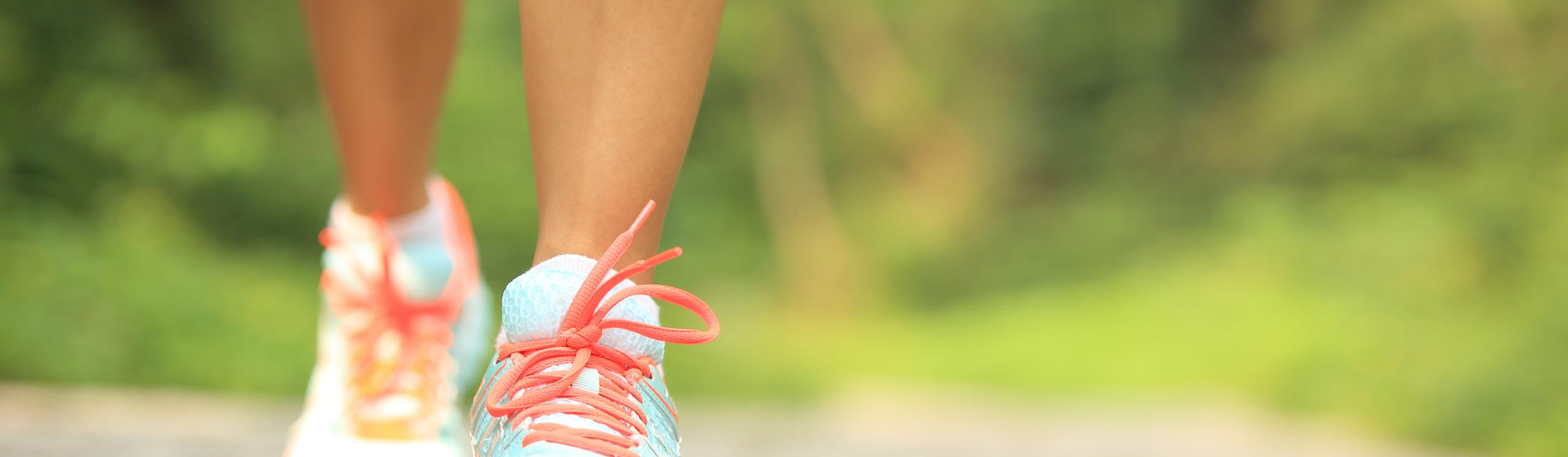 Close-up of a woman walking in sneakers.