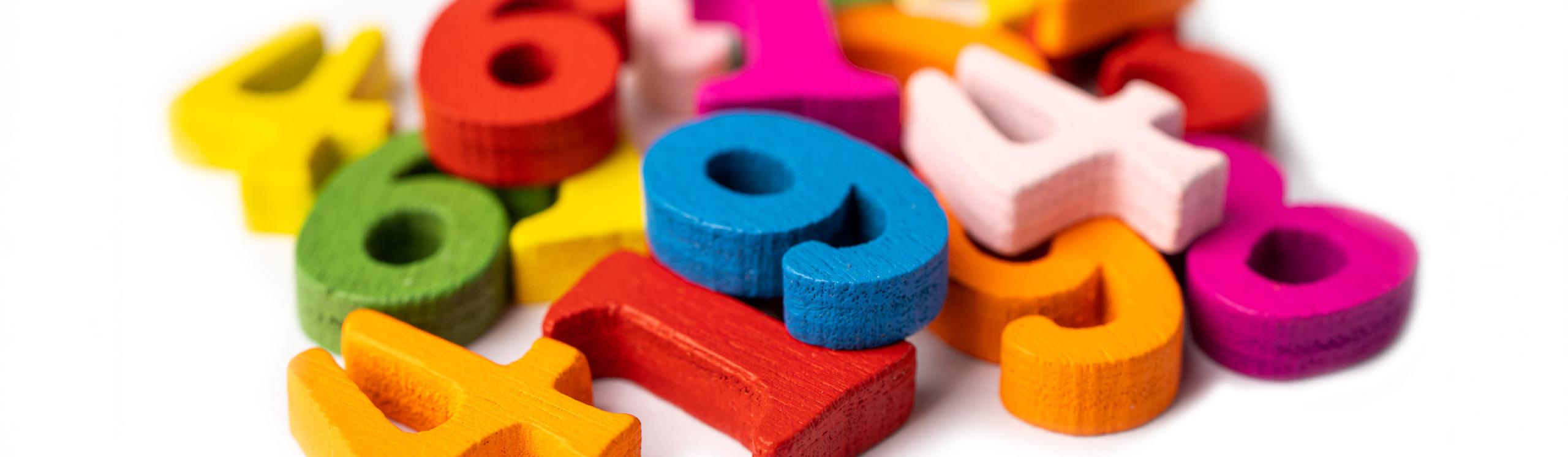 A pile of colourful wooden blocks in the shape of numbers