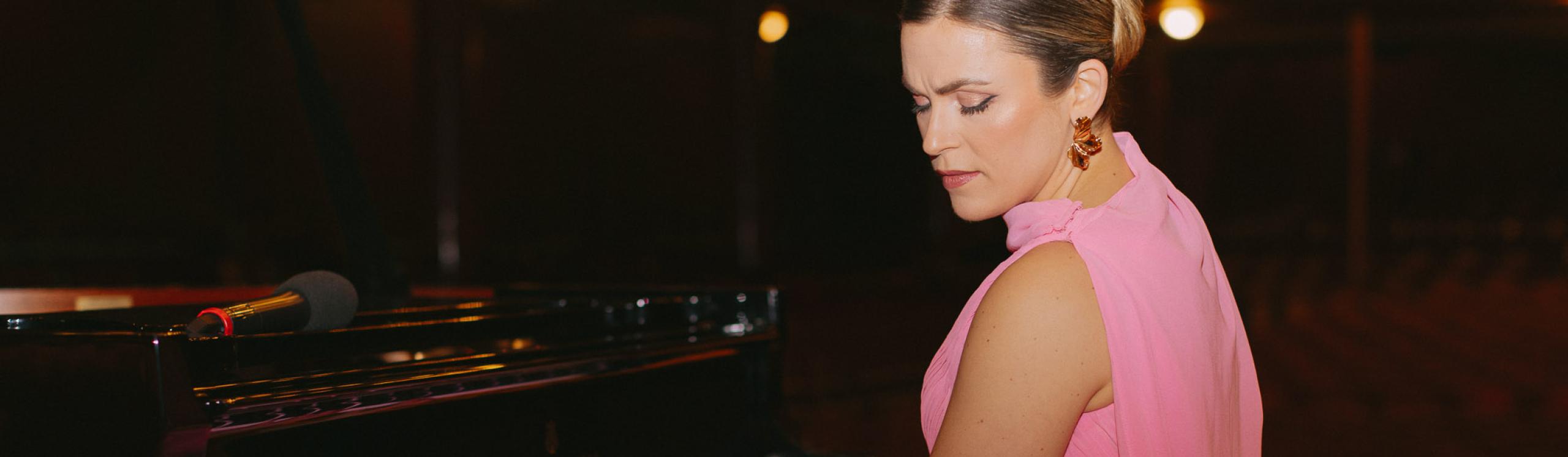 Pianist Michelle Lynne sitting at the piano with candles in the background