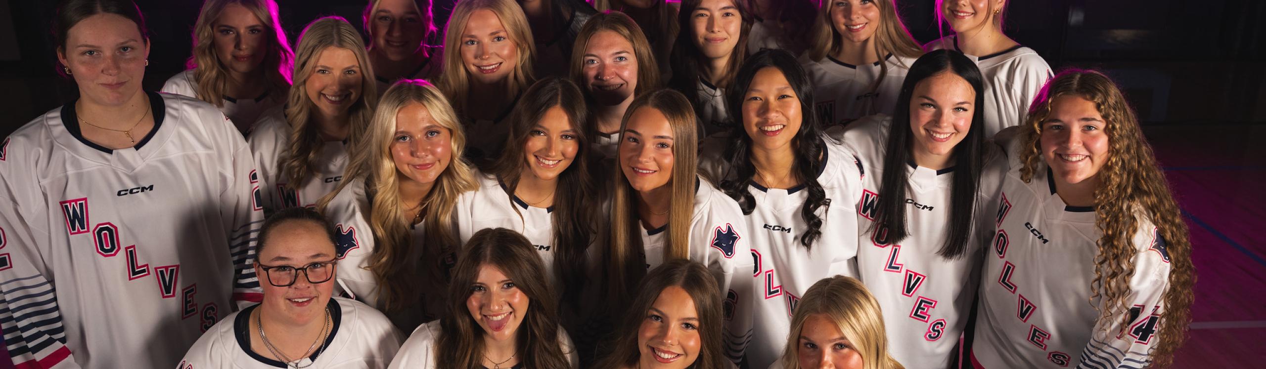 The Wolves Women's Hockey team takes a selfie while wearing their jerseys.